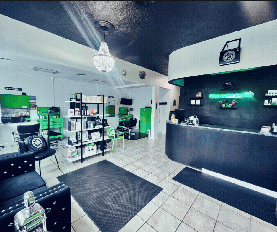 Inside The Glamour Garage, with a chandelier, green styling stations, and a chrome-trimmed reception desk