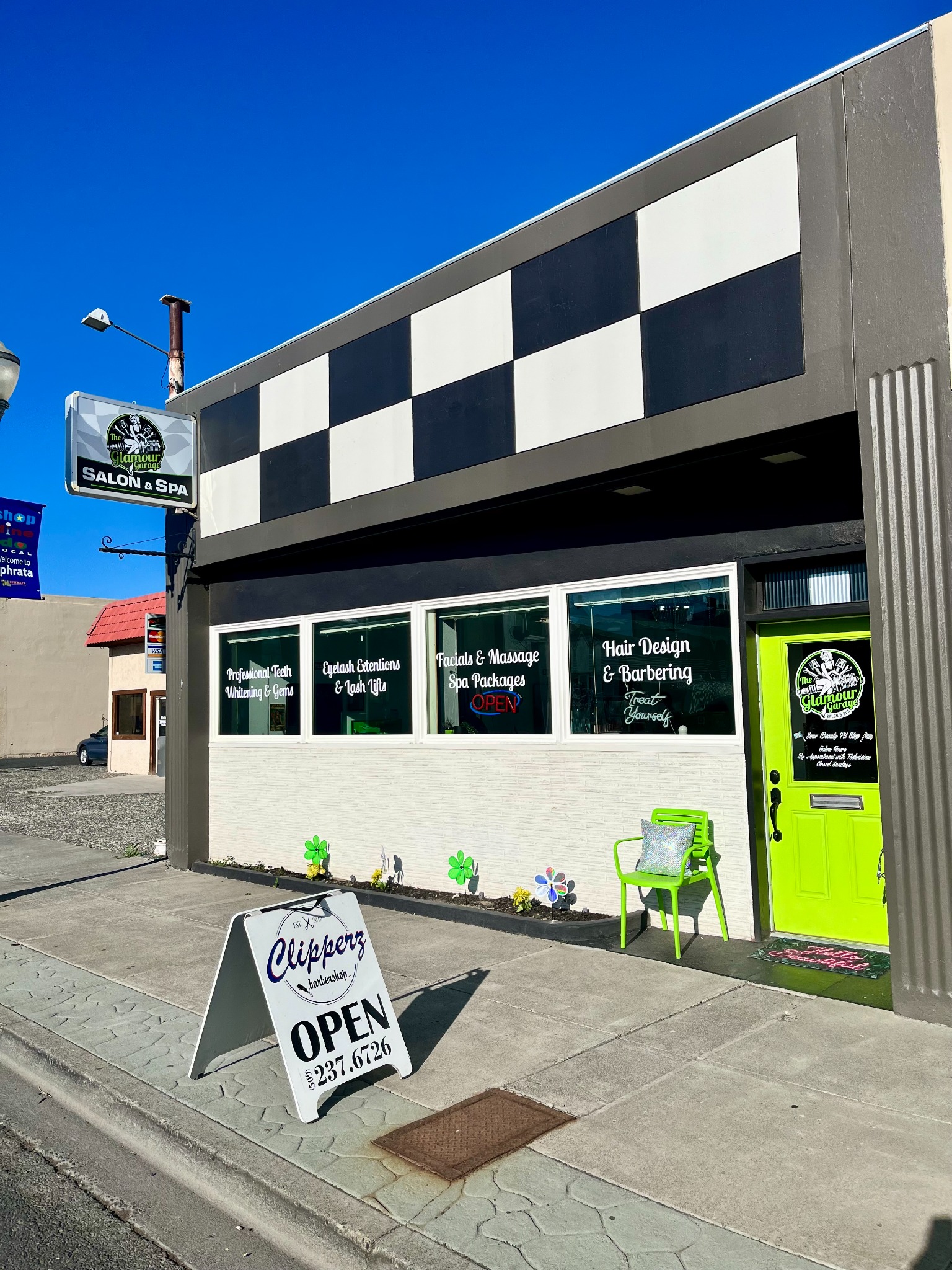 The Glamour Garage storefront with its checkered facade, salon sign, and bright green door